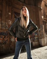 a lady wears a black leather jacket with skinny jeans